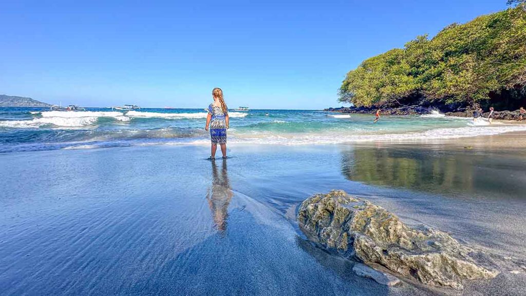 het strand van padangbai op bali met een klein kind